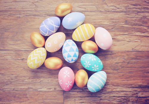 Top view of colorful easter eggs on wooden background with retro filter effect