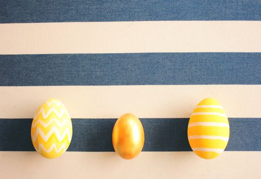 Yellow easter eggs on striped background with retro filter effect