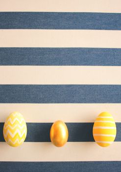 Yellow easter eggs on striped background with retro filter effect