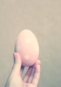 Hand holding painted easter egg with retro filter effect