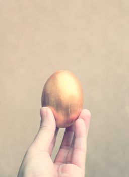 Hand holding easter egg with retro filter effect