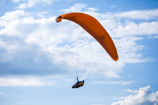 Paraglider flying on blue sky