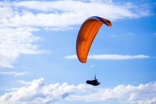 Paraglider flying on blue sky