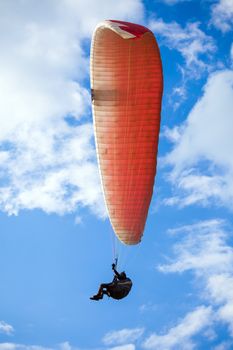 Paraglider flying on blue sky