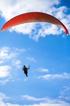 Paraglider flying on blue sky