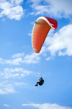 Paraglider flying on blue sky