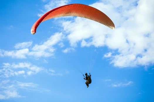 Paraglider flying on blue sky