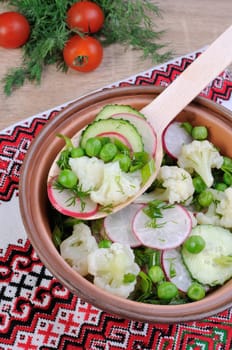 Cauliflower salad with cucumber, radish, peas and onions