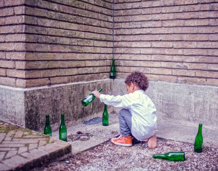 VENICE, ITALY - MAY 06: Child in the street playing with beer bottles on May 06, 2015