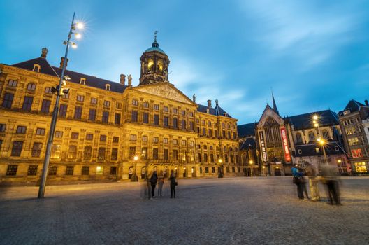 Amsterdam, Netherlands - May 7, 2015: Tourist visit Dam Square with a view of the Royal Palace and the Nieuwe Kerk in Amsterdam, Netherlands. Its notable buildings and frequent events make it one of the most well-known and important locations in the city and the country.