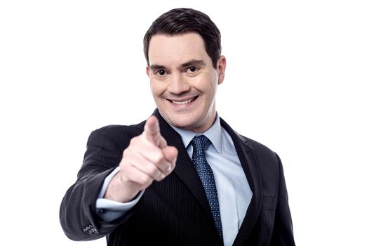 Happy businessman pointing finger at camera over white