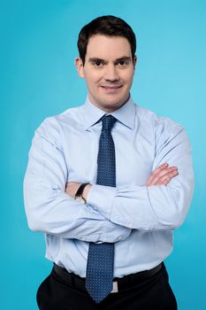 Image of a calm businessman posing with crossed arms 