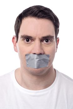 Angry man mouth covered by masking tape