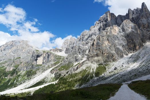 panorama of the Pale di San Martino seen from Venegia valley with clouds and blue sky background in a summer afternoon, Trentino, Dolomites