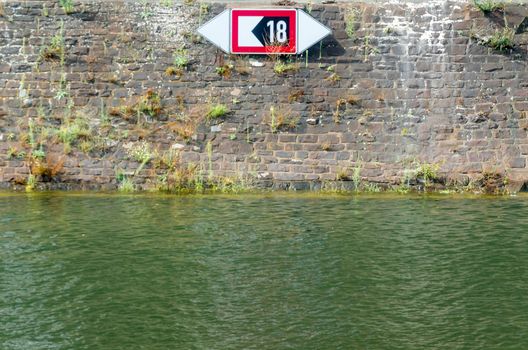 Quay wall with shipping mark sign in the harbor.