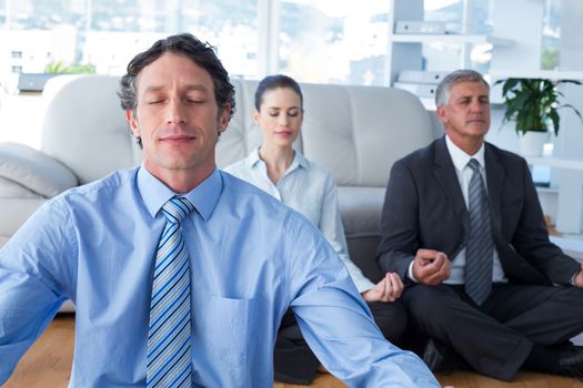 Business people practicing yoga in living room