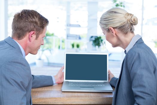 Business people watching laptop in an office