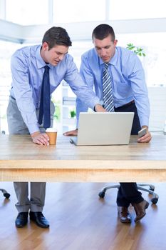 Businessmen using laptop in office