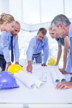 team of business people looking at construction plan in office