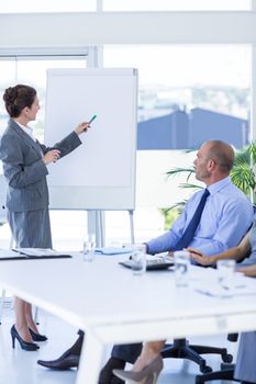 Business people looking at meeting board during conference in office 