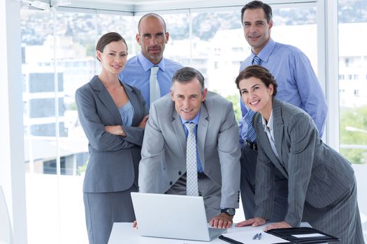 Business team working happily together on laptop in the office