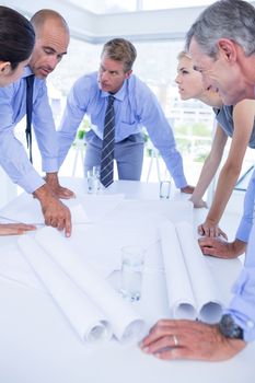 team of business people looking at construction plan in the office