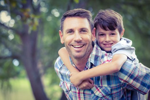 Happy child playing with his father outside in the park in summer