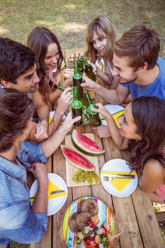 Happy friends in the park having picnic on a sunny day