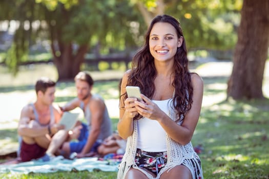 Pretty hipster using her smartphone on a sunny day