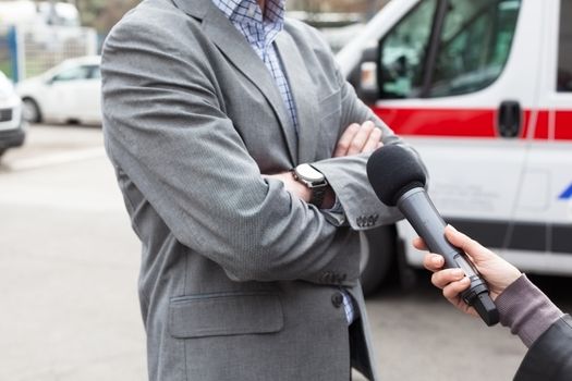 Reporter making a live broadcast, holding a microphone