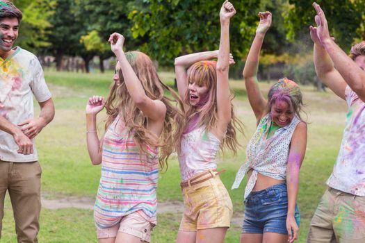 happy friends covered in powder paint on summer day 