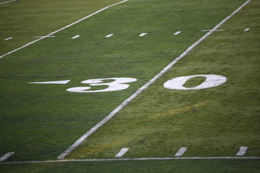 Football game 30 yard marker on a green turf field.
