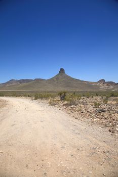 Mountain and Desert Landscape - Dirt road in the American Southwest.