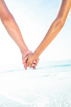 happy couple holding hands at the beach