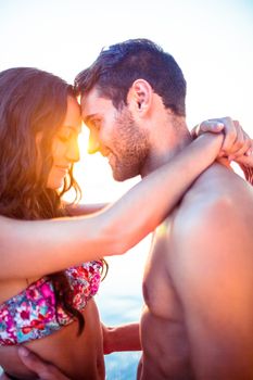 Smiling couple facing each other on the beach on holidays