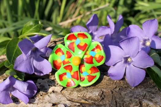 Handmade clay green ring with wood violet in spring on the nature background