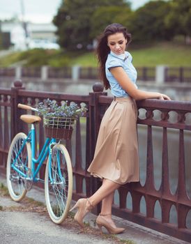 Young beautiful, elegantly dressed woman with bicycle. Beauty, fashion and lifestyle