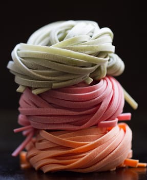 colorful pasta tagliatelle on a black background