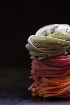 colorful pasta tagliatelle on a black background