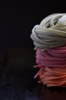 colorful pasta tagliatelle on a black background