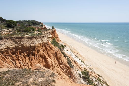 Cliffs at Praia da Falesia near villamoura in portugal area algarve with people walking at the beach