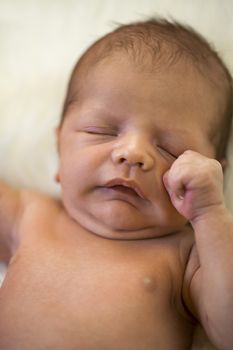 Close up Cute White New Born Baby Lying Naked on White Smooth Furry Fabric.