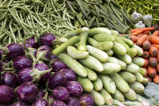 Fresh juicy vegetables, eggplant, cucumber, beans on a counter in the Indian market Goa.