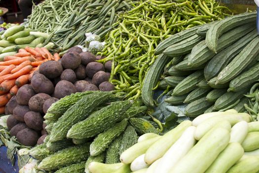 Fresh juicy vegetables, eggplant, cucumber, beans on a counter in the Indian market Goa.