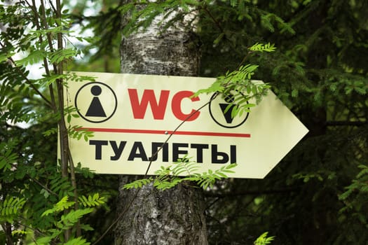 Signpost. Toilets in a conservation area in the forest