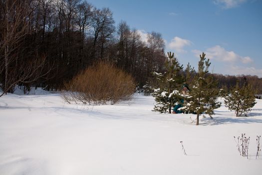 A blonde girl and a white saluki on snow
