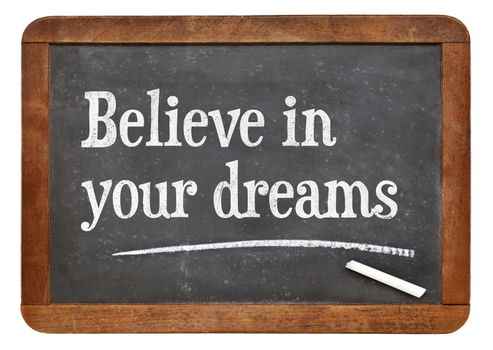 Believe in your dreams. Motivational words on a vintage slate blackboard