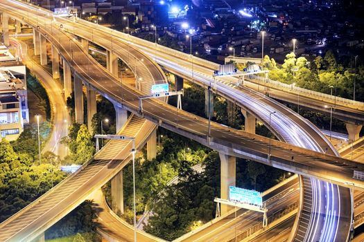 Highway traffic, light trails on the modern building background in Hong Kong