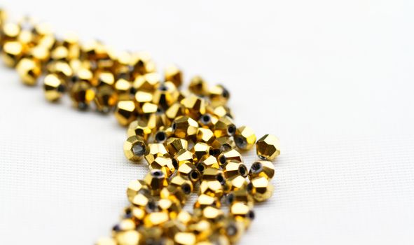 Beautiful golden glass beads closeup on white background