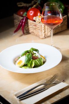 Closeup of plate of spring mix salad with strawberry, eggs and tuna